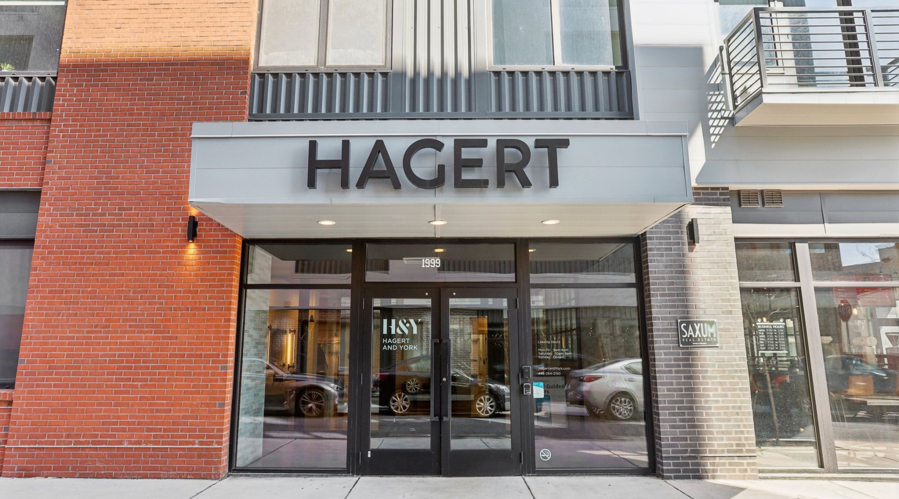 The exterior of Hagert and York Apartments in Philadelphia, PA, featuring glass doors and a modern facade.